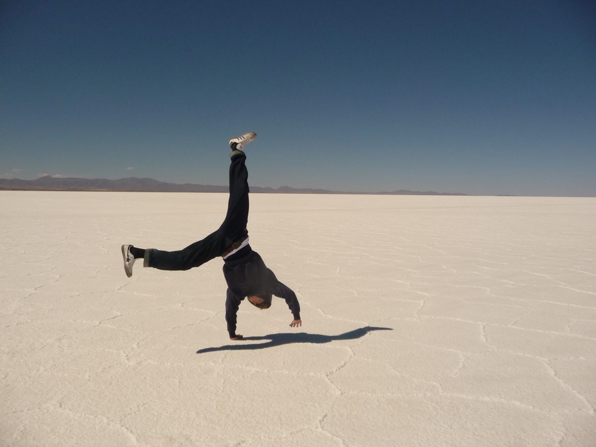 Austauschschüler macht einen Handstand auf der Salzfläche des Salar de Uyuni